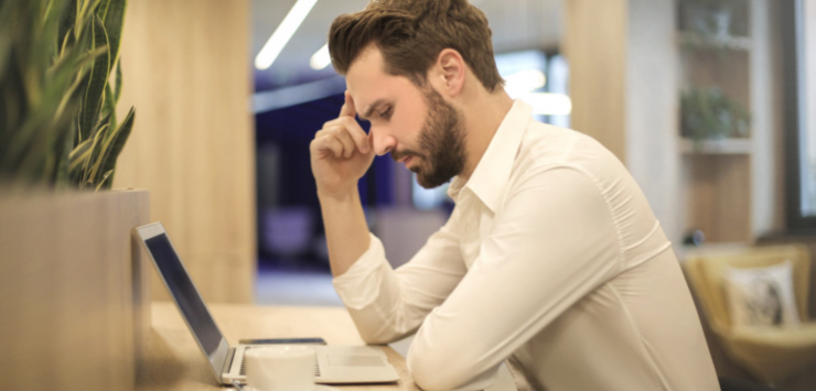 Man working on a labtop solving problems